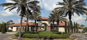 A residential building with a red-tiled roof, an arched entrance, and palm trees in the foreground. - Enchanted Palms Villa 7BR w Private Pool (Davenport)