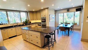 A modern kitchen with a large island, built-in appliances, and ample natural light. - Luxury Waterfront Estate · Sleeps 18 · 45-Min Drive to FIFA World Cup Stadium (East Rutherford)