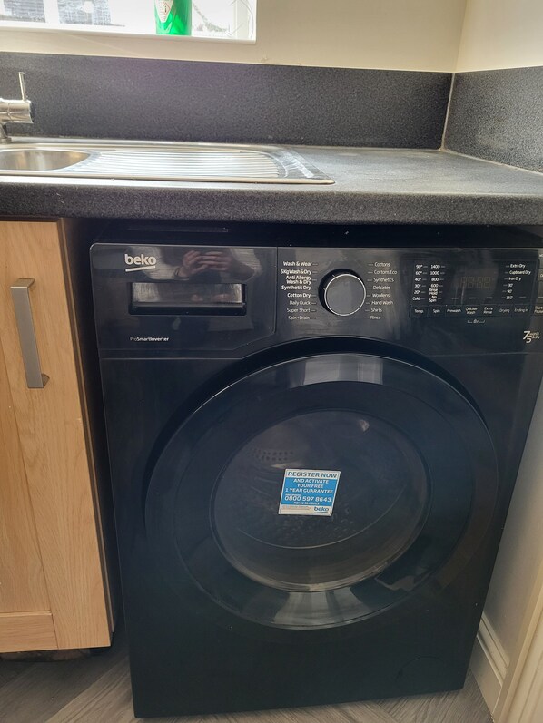 A black Beko ProSmart Inverter washing machine with a control panel listing various wash cycles and temperatures.