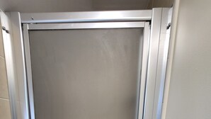 Puerta cerrada con marco metálico, incrustada en una pared de azulejos.