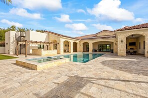 A spacious outdoor area with a swimming pool, stone patio, and multiple arches. - Centrally Located 6-bed Estate in Paradise Valley Close To Golf, Old Town, Shops (Paradise Valley)