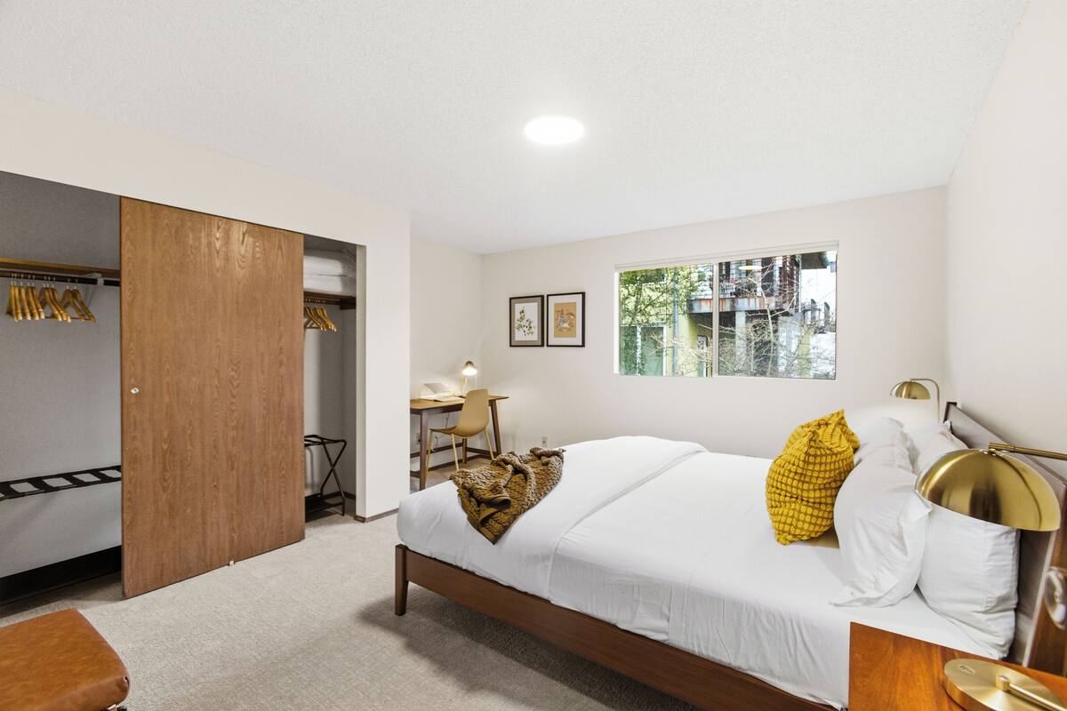 Une chambre à coucher comprenant un lit, un bureau, une chaise et une armoire.