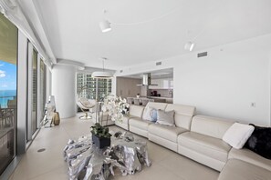 A modern living room with a sofa, coffee table, and a view of the ocean. - Ocean front PH stunning views. Luxury Spacious 4-bedroom (Hollywood)