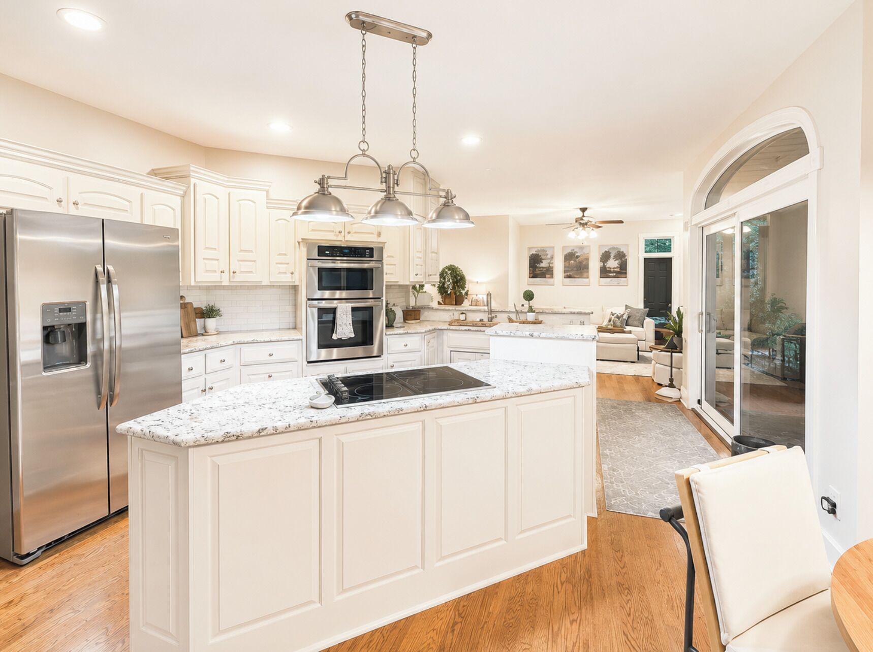 A modern kitchen with white cabinetry, stainless steel appliances, and a central island.