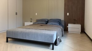 Une chambre à coucher moderne avec un lit, des tables de chevet et une armoire.