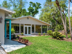 A modern single-story house with a covered porch, large windows, and a well-maintained lawn. - Beach Access + Community Dock | Coastal Retreat (Englewood)