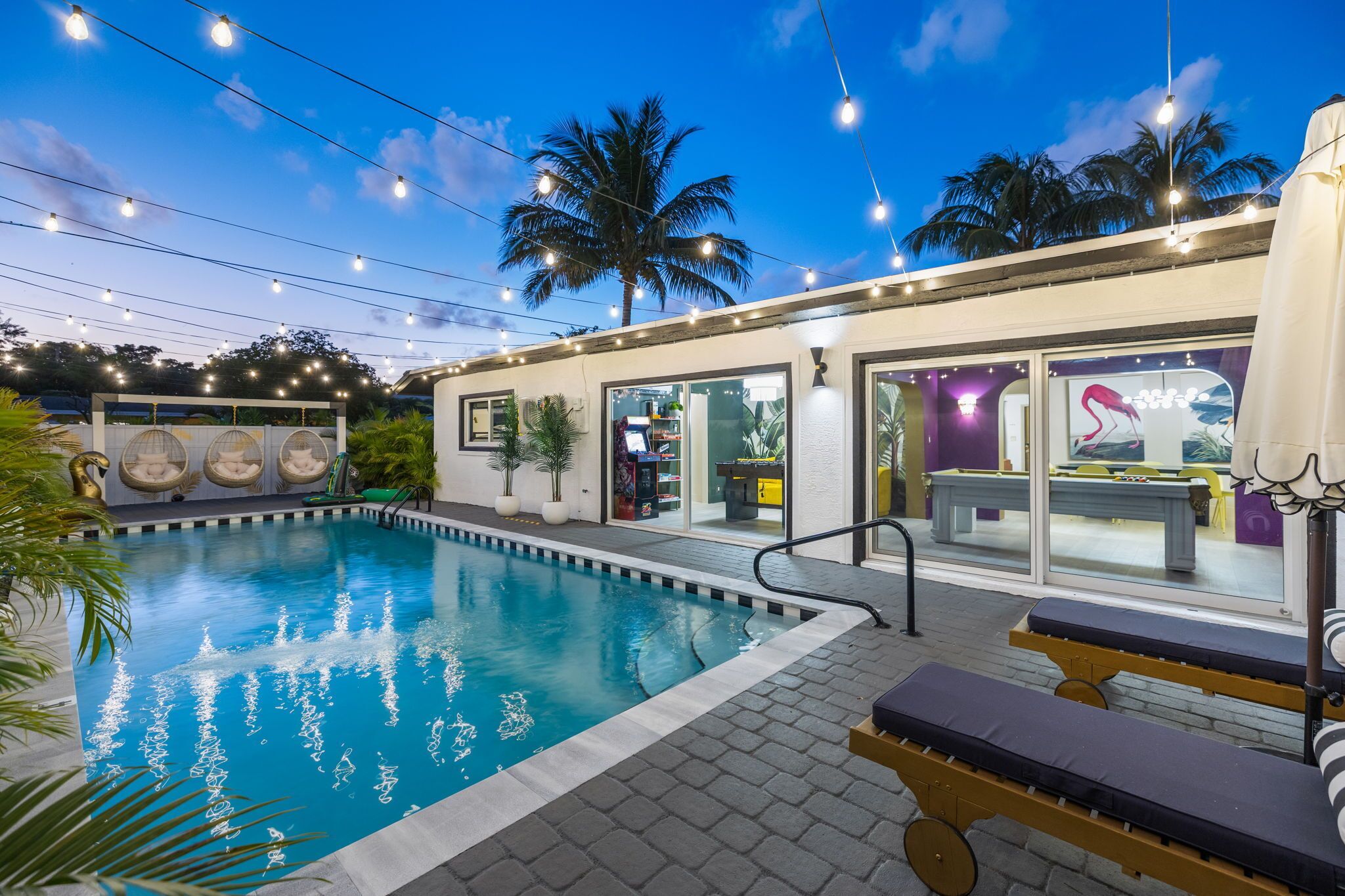 An outdoor swimming pool with lounge chairs and a restaurant area.