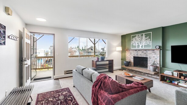 Een moderne woonkamer met een open haard, een bank, een salontafel en een televisie.