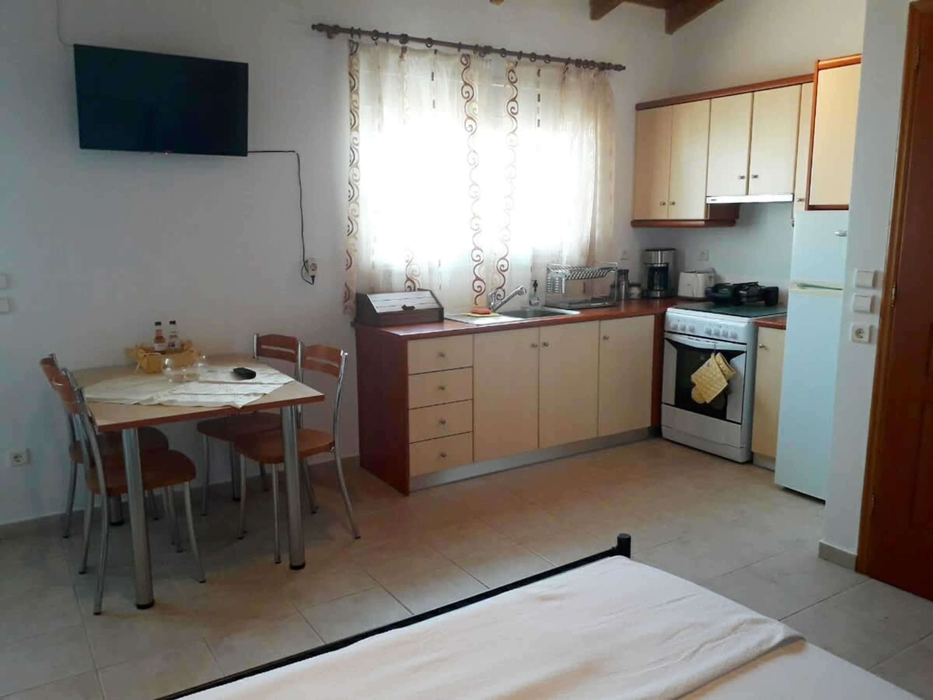 Une cuisine de taille réduite comprenant un coin repas, une seule plaque de cuisson et une petite table avec des chaises.