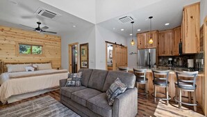 Un interior moderno con un sofá, una cama y una zona de cocina.