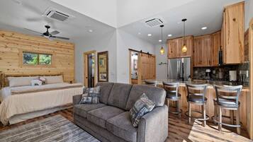 A modern interior with a sofa, a bed, and a kitchen area.