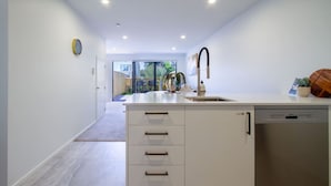 Una cocina moderna con lavavajillas integrado, una isla grande con cajones y un ventanal con vistas al exterior.