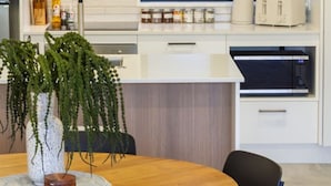 Una cocina moderna con armarios de madera, una ventana y un comedor con mesa y sillas.