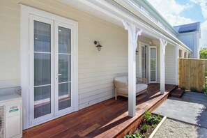 A house with a covered porch, white siding, and a wooden deck. - Classic and Comfy Townhouse + Carpark on Colombo (Christchurch)