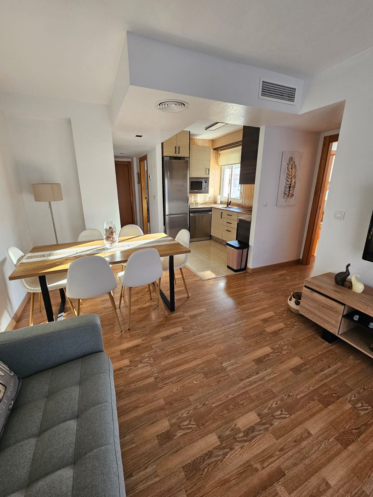 A modern apartment with a dining area, kitchen, and living space.