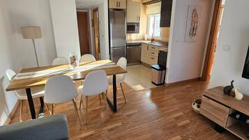 A modern apartment with a dining area, kitchen, and living space.