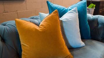 A blue sofa with three cushions in different colors.