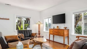 Una sala de estar con sofá, mesa de centro, lámpara y televisor.