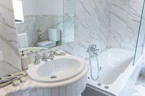 A bathroom with a marble sink, a bathtub, a toilet, and a mirror. - Notino Boutique Apartment - Luxurious Apartment in the Heart of Sorrento (Sorrento)