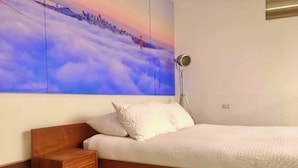 Una camera da letto moderna con una struttura letto in legno, un comodino e un grande murale sulla parete.