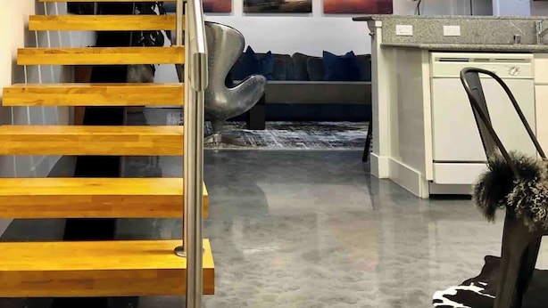 Un interno moderno con una scala in legno, un'area pranzo e una cucina.