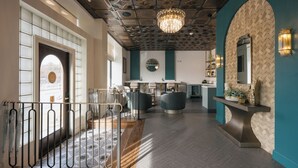 Un intérieur moderne avec un îlot central, des luminaires suspendus et un mur orné d’un motif en chevrons.
