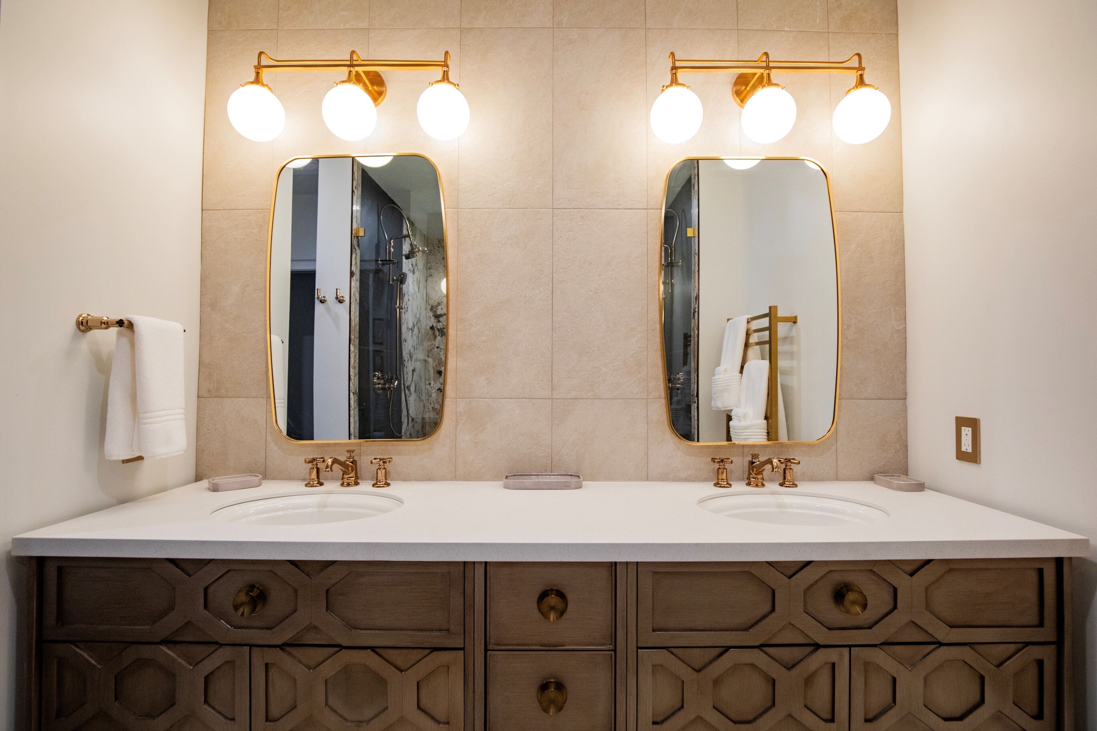 Un baño con dos lavamanos, un espejo grande y un mueble tocador con cajones.