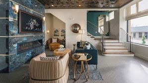 Un salon moderne avec une cheminée, un canapé, une table basse et un escalier menant à un niveau supérieur.