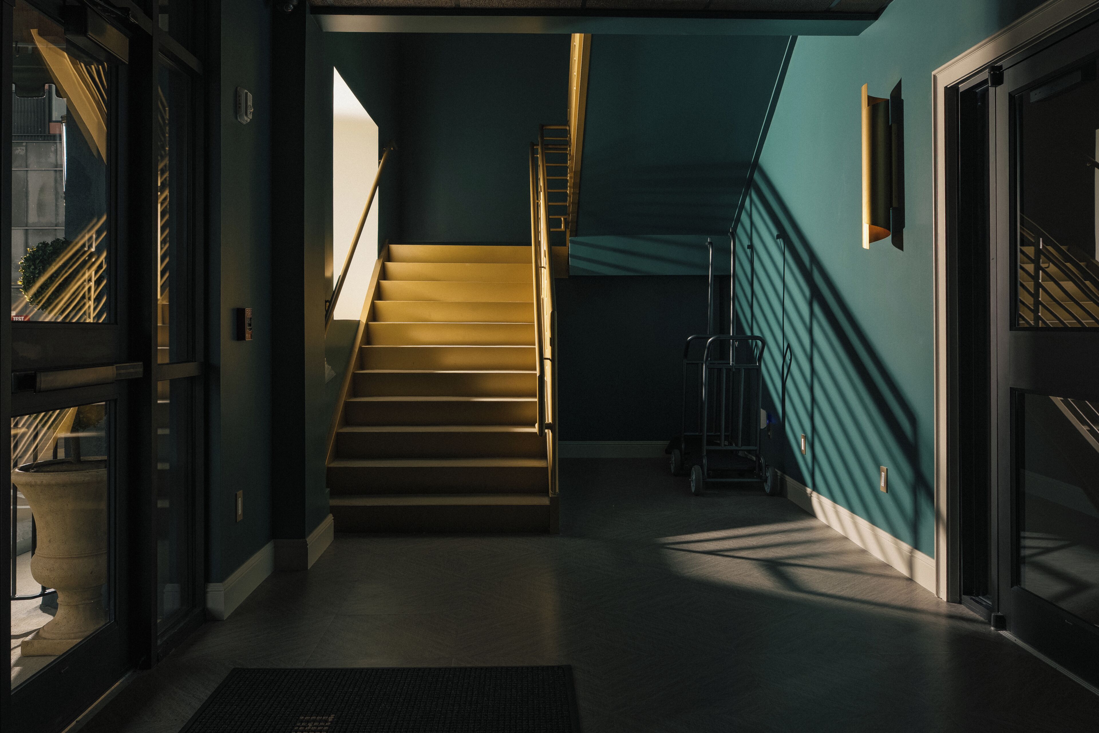 A staircase leading to a landing with a view of a building outside.