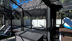 An outdoor deck with a wooden bench, a small table, and a covered seating area. - Spacious 5-bedroom Pool Home near Beaches-Hot Tub, Kayaks, Massage Chair (North Port)