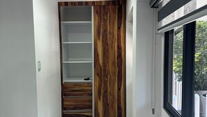 Un interior moderno con una estantería de madera empotrada, piso de mármol y ventana con vista a la vegetación.