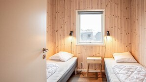 A room with two beds, a small table, and a window. - Gorgeous home in Grenaa with sauna (Grenaa)