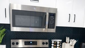 A kitchen with a stainless steel microwave, oven, and stovetop, with a sign reading 'Welcome To Speake.' - Apartment in Spokane (Spokane)