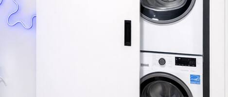 A modern laundry room with a wall-mounted dryer and a large sliding door.