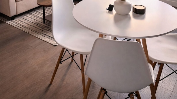 A modern living room with a sofa, coffee table, and dining table, a cityscape view, and a wall art piece. - Apartment in Spokane (Spokane)
