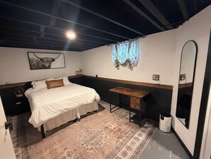 Une chambre à coucher avec un lit, une table de chevet, un miroir et un tapis.