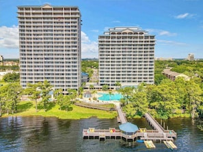 A high-rise hotel with multiple balconies, a swimming pool, and a dock extending into a body of water. - Balcony Lake Views |  Pool, Gym, WiFi & Parking (Orlando)