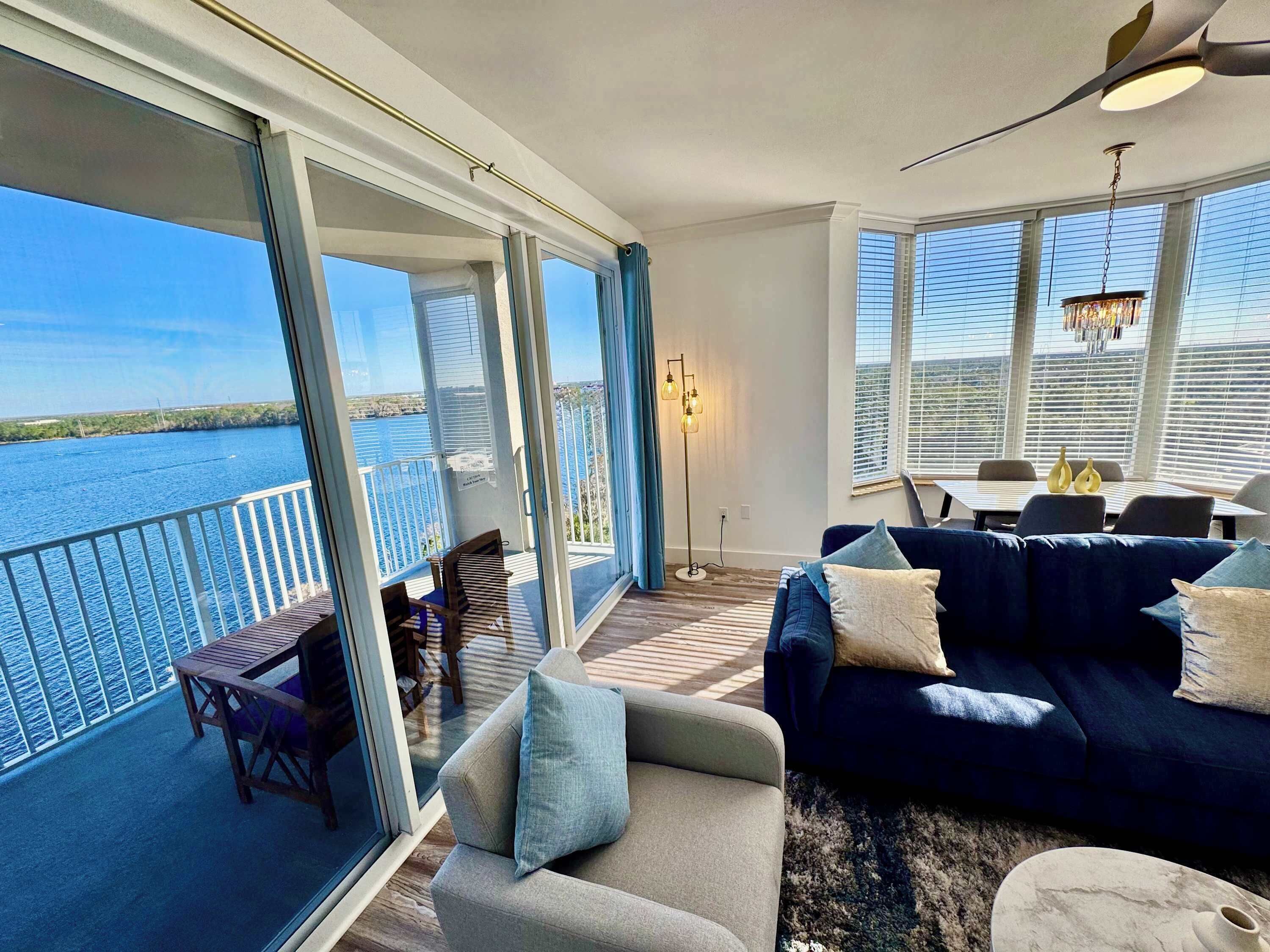 En rummelig balkon med havudsigt, et siddeområde med sofa og stole, samt et spisebord med stole.