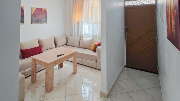 Un salon comprenant un canapé, une table basse et une porte agrémentée d’un portail décoratif en métal.