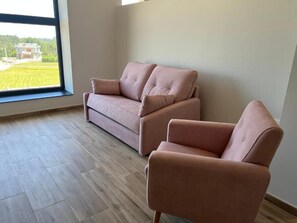 Kolmen hengen deluxe-huone, merinäköala | Oleskelualue | Älytelevisio, Netflix, maksullisia elokuvia, suoratoistopalvelut