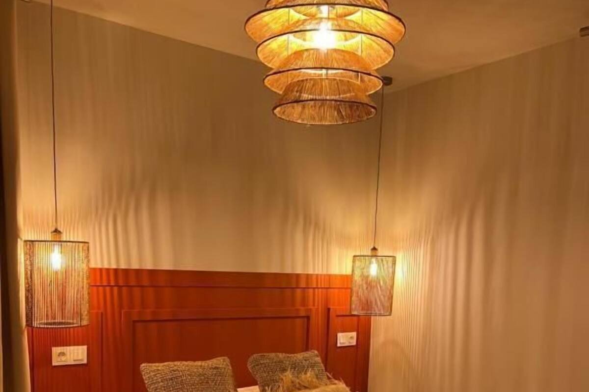 Ein Hotelzimmer mit einem großen Bett, zwei Nachttischen und einem Holzkopfteil.