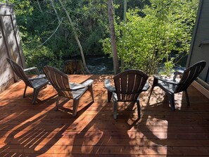 A wooden deck with four Adirondack chairs facing a natural backdrop. - Andora Villa Unit 116, Walk to Town, River Run 1/2 mile, Deck on Trail Creek!! (Ketchum)