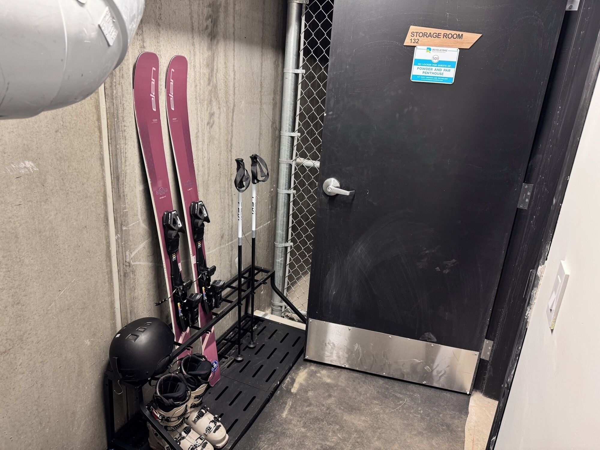 A storage room with skis, ski poles, and helmets.
