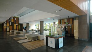 Eine großzügige Lobby mit modernem Design, inklusive einer Modellvitrine und Sitzbereichen.
