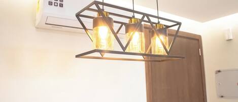 Una cocina moderna con aire acondicionado integrado, iluminación colgante y una puerta de madera.