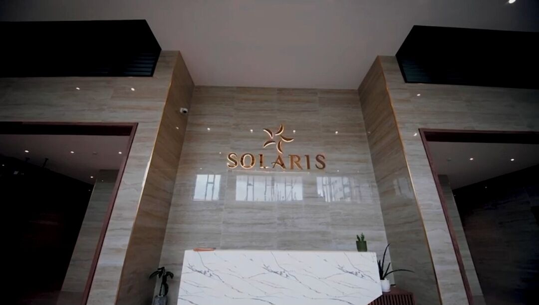 A reception area with a marble counter and the name 'SOLARIS' prominently displayed above.