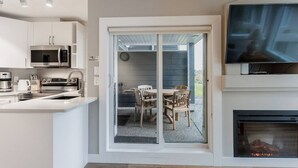 Une cuisine moderne équipée d’un four à micro-ondes, d’une machine à café et d’un coin repas avec une table et des chaises.