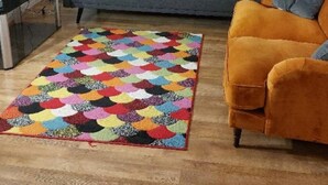 A living room with a sofa, a colorful rug, a television, and a chandelier. - Citylink 2-bedroom flat, 8 mins to London bridge. Sleeps 7. (London)