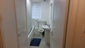 A narrow bathroom with a toilet, sink, and shower area. - Citylink 2-bedroom flat, 8 mins to London bridge. Sleeps 7. (London)