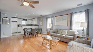 A spacious living area with a dining table, a sofa, and a ceiling fan. - Casa Havana | Old Town Condo w/ Pool & Balcony (Key West)